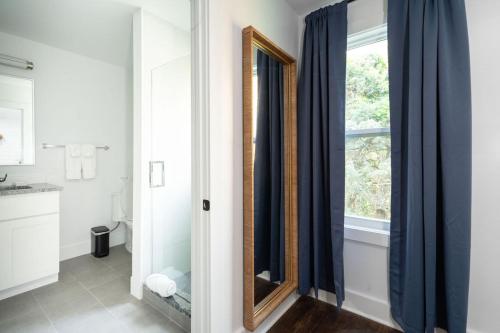a bathroom with a mirror next to a window at The Silver Lake Hotel at Ocracoke in Ocracoke