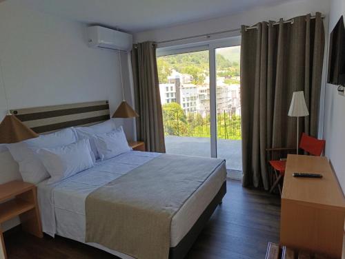a hotel room with a bed and a large window at Casa do Patrão Serradalto in Manteigas