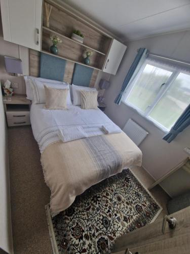 ein großes Bett in einem kleinen Zimmer mit Fenster in der Unterkunft Maise's in Camber