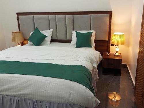 a bedroom with a large bed with green and white pillows at Peaceful Home in Kigali
