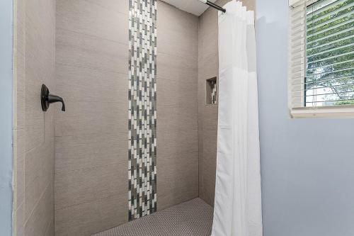 a bathroom with a shower with a shower curtain at Sanibel Sandals & Flip Flops in Sanibel