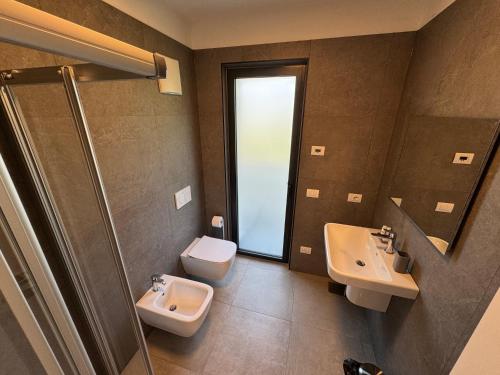 a bathroom with two sinks and a toilet and a shower at Appartamenti Nataly in Nago-Torbole