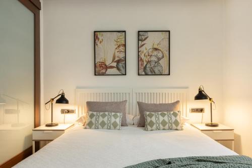 a bedroom with a bed with three pictures on the wall at Portu Casa Albero I Aston Rentals in Portugalete