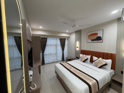 a bedroom with a large bed and a bathroom at Hotel Prime Divine in Ahmedabad