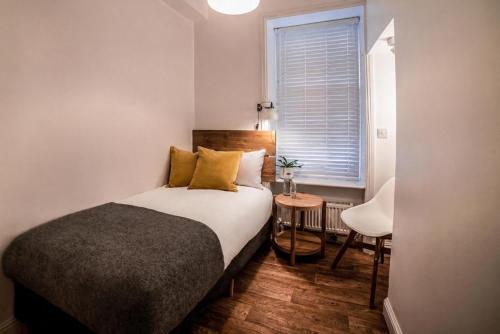 a small bedroom with a bed and a window at Black Cat in Galway