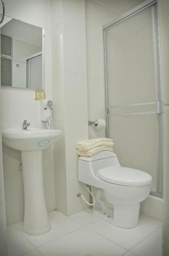 a white bathroom with a toilet and a sink at Le Prince Arica in Arica