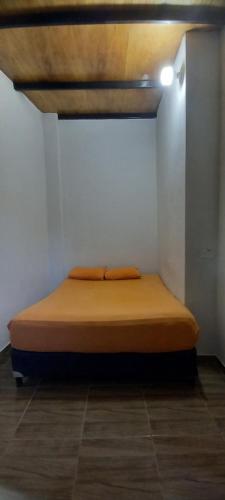 a bed in a room with a white wall at Quinta Sinaí in Encarnación