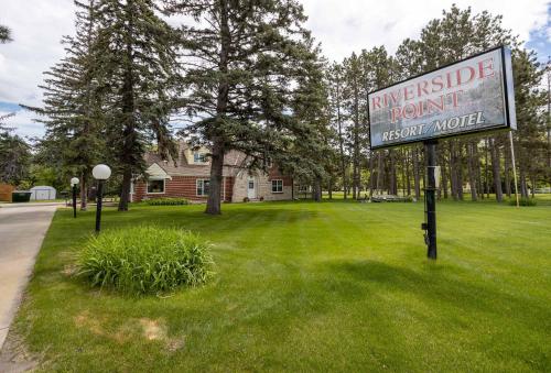 a sign in the grass in front of a house at 2BR 1BA Cabin #8 at Riverside Point Resort in Park Rapids