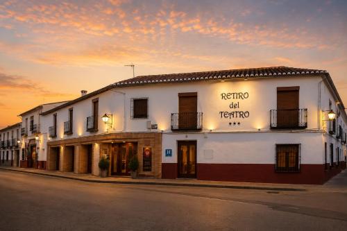 a white building with a sign on the side of it at RETIRO DEL TEATRO Hotel Boutique y Apartamentos en Almagro in Almagro