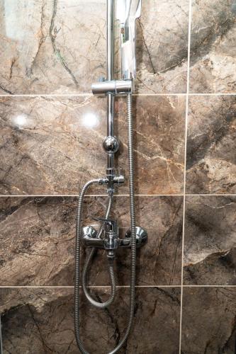 a shower in a bathroom with a stone wall at Villa Mali Raj in Čapljina