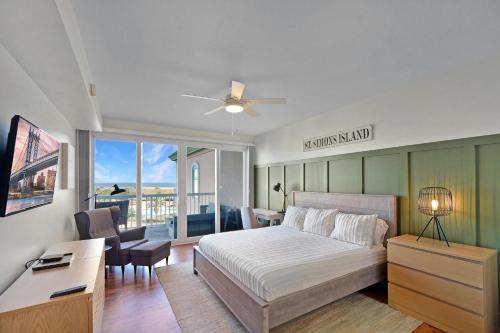 a bedroom with a bed and a desk and a window at St. Simons Grand 307 in Saint Simons Island