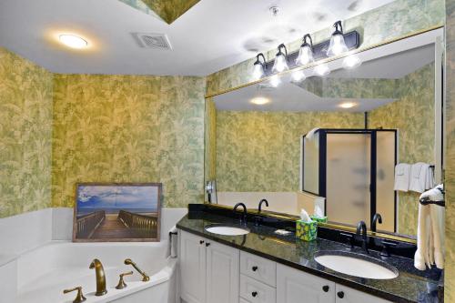 a bathroom with two sinks and a large mirror at St. Simons Grand 307 in Saint Simons Island