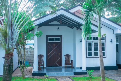 a house with two chairs and a door at Breeze 12 Villa in Negombo