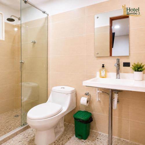 a bathroom with a toilet and a shower and a sink at Hotel Bambù 2 in Puerto Asís