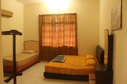 a small room with two beds and a window at kluanghomestayvilla in Kluang