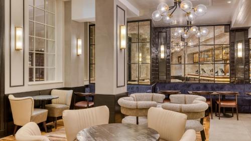 a restaurant with tables and chairs and a chandelier at hub London Farringdon - Old Bailey in London