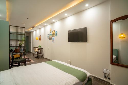 a bedroom with a bed and a tv on the wall at Hanoi Olive Boutique in Hanoi
