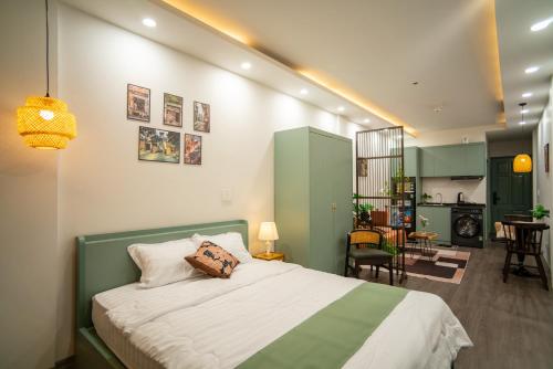 a bedroom with a green and white bed and a kitchen at Hanoi Olive Boutique in Hanoi