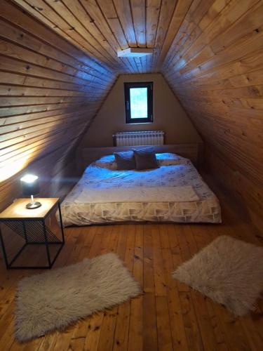 a bedroom with a bed and two rugs at Planinska Kućica in Mostar