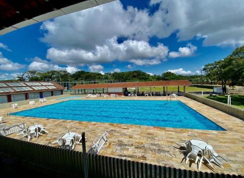 a large blue swimming pool with chairs around it at Pousada Fecep in Guaratuba