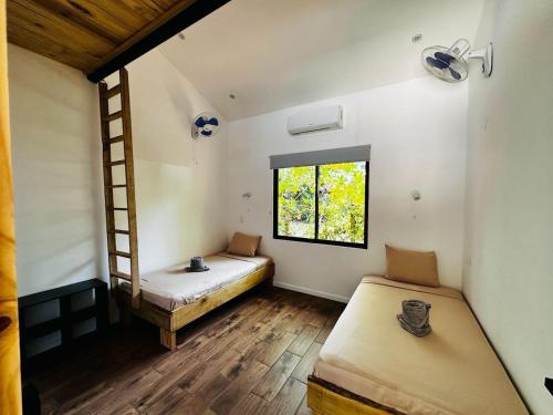 a room with two beds and a ladder at Between Waves and Woods in Sámara