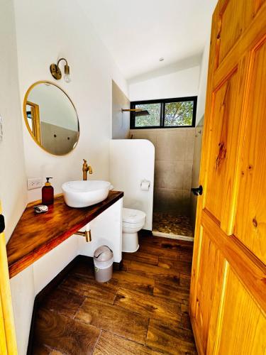 a bathroom with a sink and a toilet and a mirror at Between Waves and Woods in Sámara