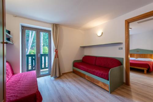 a room with a red couch and a bed at Residenza Lorica in Lorica