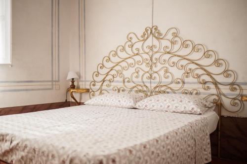 a bedroom with a white bed with a metal headboard at Villa Maddalena - Cerrolungo in Isola