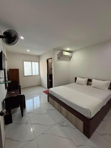 a bedroom with a bed and a desk in it at SLV Royal Residency Hotel in Bidadi
