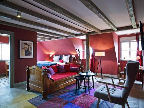 a bedroom with a bed and a red wall at Auberge de Temple in Johannesberg