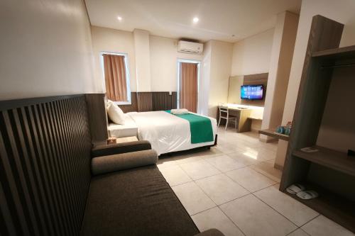 a hotel room with a bed and a couch at Nivasa Hotel in Nusa Dua