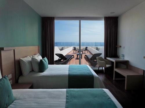 a hotel room with two beds and a balcony at Hotel Plaza Sol Veracruz in Veracruz