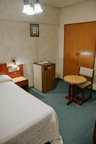 a hotel room with a bed and a table and a desk at Eleven Palace Hotel in Buenos Aires