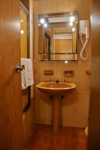 a bathroom with a sink and a mirror at Eleven Palace Hotel in Buenos Aires
