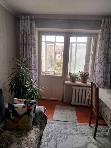a living room with a couch and a window at Beka guest house in Karakol
