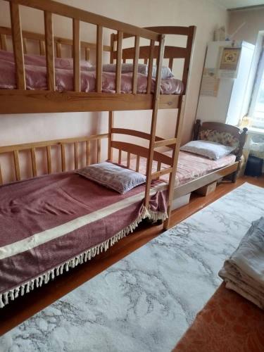 two bunk beds in a room with a rug at Beka guest house in Karakol