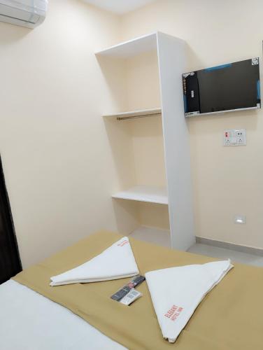 a table with papers on it next to a shelf at Elegant Inn Hotel in Surat