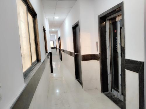 a hallway with doors and windows in a building at Elegant Inn Hotel in Surat
