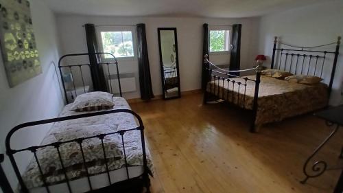 a room with two beds and a mirror at Kilomètre creusois in Saint-Dizier-Leyrenne