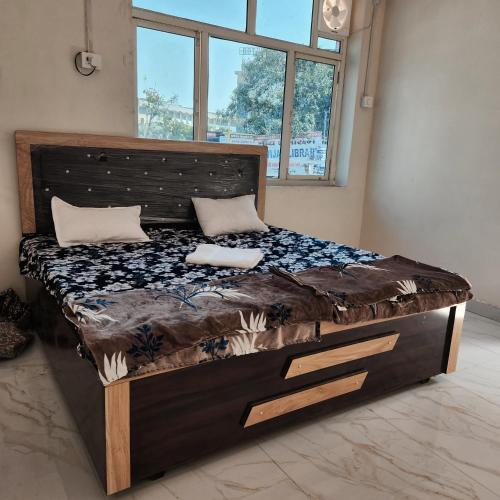 a large bed in a room with a large window at Shri om paradise inn in Mathura