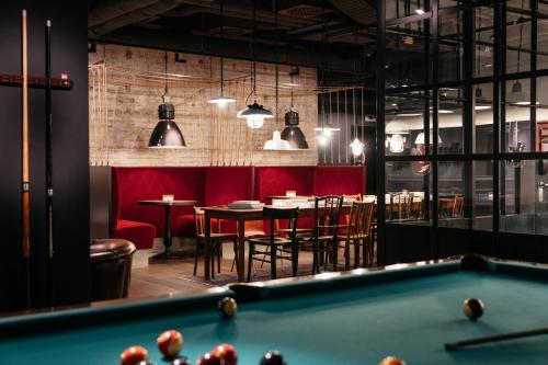 ein Billardtisch in einem Restaurant mit Tischen und Stühlen in der Unterkunft Ruby Leni Hotel Dusseldorf by IHG in Düsseldorf