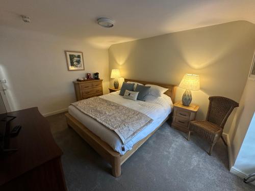 a bedroom with a bed and two lamps and a chair at Tafarn Penllan White Horse in Llanrwst