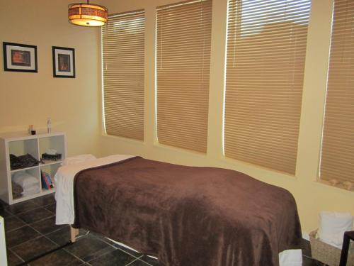 a bedroom with a bed in a room with windows at Super 8 by Wyndham West Kelowna BC in West Kelowna