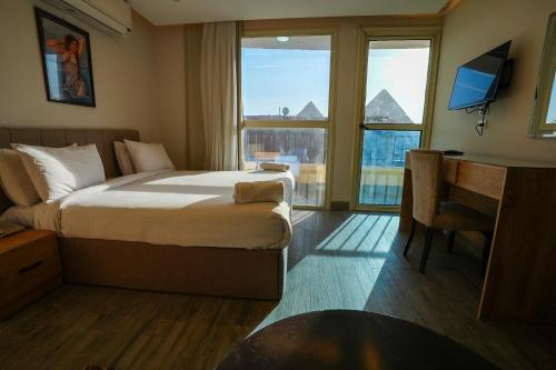 a hotel room with a bed and a desk and window at Pyramids Hostel in Cairo