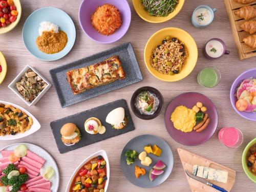 a table with plates of food and bowls of food at Mercure Urabandai Resort & Spa in Kitashiobara