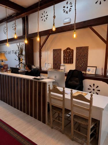an office with a reception desk and a woman sitting at a counter at RETIRO DEL TEATRO Hotel Boutique y Apartamentos en Almagro in Almagro