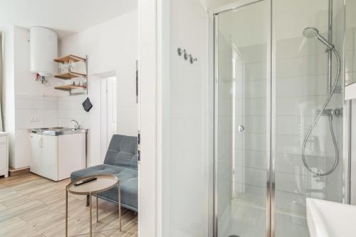 a bathroom with a shower and a blue chair at cityswap- Wien 2 District in Vienna