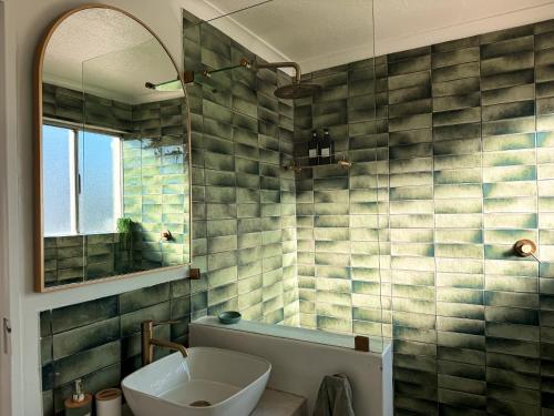 a bathroom with a sink and a tub and a mirror at Coastal Living in Hermanus