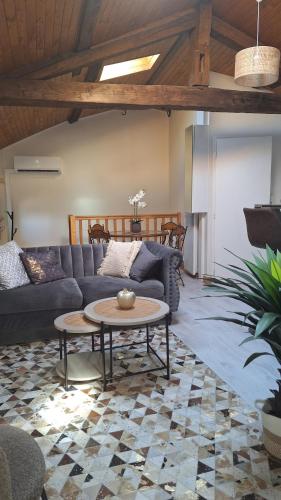 a living room with a couch and a table at La tête dans les étoiles - Appartement climatisé - 2 Chambres in Ruffec