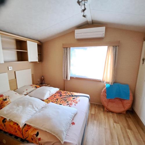 a small bedroom with two beds and a window at Camping les cigales 5 étoiles in Le Muy